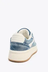 Zapatillas deportivas de denim azul con detalles en cuero sintético blanco.