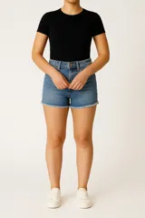 Short de jean color crudo, tiro medio, corte ajustado y ruedo desflecado.