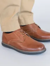 Zapato casual de cuero color whisky con ajuste de cordones y suela de Eva con cortes que brindan mayor flexibilidad al caminar.