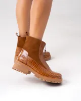 Bota de cuero color marrón, con diseño tipo croc y cierre frontal.