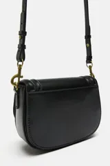 Bolso bandolera color marrón con solapa y correa ancha de tela color crudo.