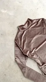 Body de terciopelo marrón con estampado de piel de serpiente, cuello alto, mangas largas con orificio para el pulgar y espalda descubierta.