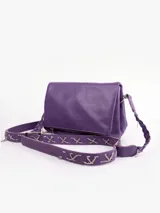 Bandolera de cuero color violeta con correa ancha decorada con apliques metálicos.
