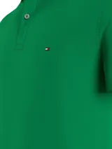 Chomba verde de corte slim, con cuello polo, tapeta de dos botones y logo de Tommy Hilfiger bordado en el pecho.