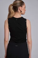 Musculosa marrón de tejido liso, con cuello redondo y tachas metálicas decorativas en los hombros.