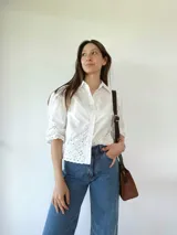 Cartera bandolera de cuero color marrón tostado, con doble asa corta y correa larga desmontable. Tiene un bolsillo frontal con cierre y un bolsillo interno.