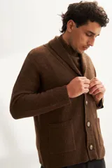 Cardigan tejido color marrón con cuello smoking, cierre con botones y bolsillos delanteros.