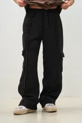 Pantalón jogger negro de corte ancho con bolsillos cargo y cordón ajustable en la cintura.