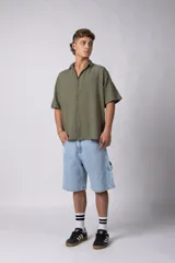 Camisa verde militar de lino con cuello clásico, manga corta y cierre frontal con botones.