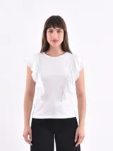 Remera blanca de mangas cortas con volados en los hombros.
