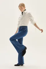 Jean acampanado de tiro alto, color azul medio, confeccionado en denim con un pequeño porcentaje de elastano.