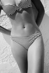 Braguita de bikini de tiro medio con cintura elástica y forro interior. Diseño a rayas horizontales blancas y negras.
