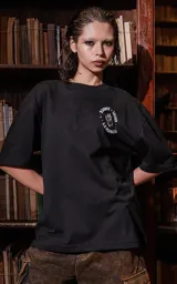 Remera negra de manga corta con cuello redondo y calce oversize. Estampa frontal con diseño de tarot con un león y la leyenda "Tarot x Luxo - La Fuerza".