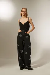 Pantalón de jean negro de corte ancho con estrellas plateadas.