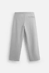 Pantalón jogger gris de corte recto, confeccionado en tejido de algodón compacto con interior en rizo. Cuenta con cintura elástica ajustable con cordón interior, bolsillos frontales y bolsillo de doble vivo en la espalda.