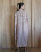 Vestido camisero de denim azul con cuello clásico, cierre frontal con botones y mangas cortas con dobladillo.