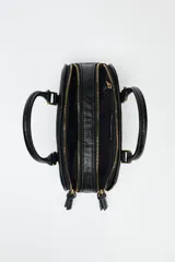 Bolso mini tipo bowling color negro, con doble compartimento con cierre de cremallera, asa de mano y asa bandolera extraíble.