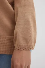 Sweater lila de tejido de punto, con escote en V y mangas largas.
