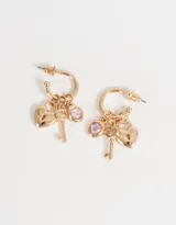 Aros dorados tipo argolla con dije de corazón con strass rosa y llave colgando.