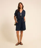 Short femenino en piquet azul marino, con cintura fija con trabilla y cordón para ajustes, cierre tradicional con botón, detalles de pliegues delanteros y corte más holgado.