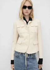 Blazer color crudo confeccionado en tejido tweed con mezcla de algodón y lana. Presenta cuello de pico con solapa, dos bolsillos de parche en el pecho, solapas con muesca, diseño recto, dos bolsillos de solapa en la parte delantera, cierre delantero con botones, diseño entallado y forro interior.