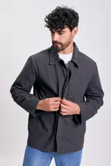 Campera de color negro para hombre, con cuello camisero, cierre frontal de botones y bolsillos aplicados en el frente.