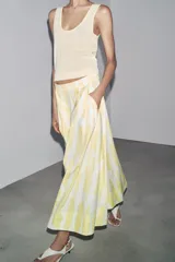 Falda midi de tiro alto confeccionada en hilatura de algodón con estampado geométrico en tonos rosa, marrón y bordó. Detalle de pliegues en cintura y bajo evasé. Cierre con cremallera oculta en costura.