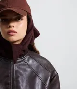 Campera bomber femenina de cuero sintético color marrón oscuro, con cuello alto, frisos en los hombros, puños y bajo ajustados, y cierre delantero con cremallera.