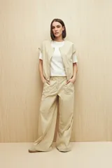 Pantalón color beige de corte ancho y tiro alto, con bolsillos delanteros amplios.