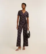 Mono largo de microfibra con estampado geométrico en tonos marrones y blancos. Tiene escote en V, mangas cortas y lazo ajustable en la cintura.