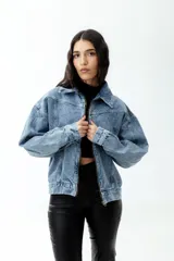 Campera de jean celeste con lavado ácido, corte cropped y cierre frontal con cremallera metálica.