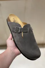 Zuecos grises marca Plakton, confeccionados en cuero vacuno, con hebilla lateral ajustable, plantilla anatómica con memory cushion y suela de goma y corcho.