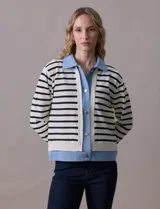 Campera combinada marca Nanette, con torso y mangas en tejido a rayas horizontales blancas y negras. Solapa, puños y cierre en denim celeste. Cierre frontal con botones metalizados.