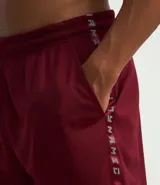 Bermuda deportiva color borgoña, con cintura elástica ajustable con cordón, bolsillos laterales y estampado lateral con la palabra 'Get Over'. Confeccionada con tecnología Dry que facilita la evaporación del sudor.