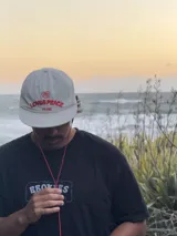 Gorro de visera curva color beige claro, con bordado frontal que incluye un corazón rojo con las letras "ZTH" y el texto "LOVE & PEACE PP.ONE" en rojo.