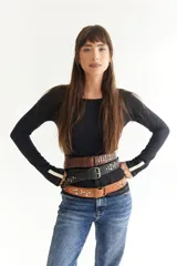 Cinto de cuero color marrón con hebilla metálica y tachas plateadas.