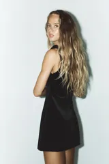 Vestido corto negro de terciopelo, con escote cuadrado y tirantes gruesos con detalle de lazos.