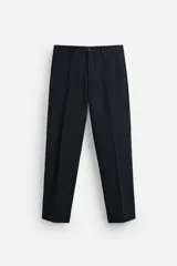 Pantalón de vestir azul marino, de corte slim fit, con bolsillos laterales y traseros. Se ajusta a la cintura con cinturón de cuero marrón.