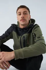 Campera verde militar para hombre con capucha ajustable, cierre frontal completo, bolsillos laterales con cierre y logo estampado en el pecho. Presenta detalles en negro en la parte superior del pecho, hombros y mangas.