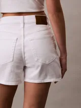 Short blanco de tiro alto con diseño de 5 bolsillos, cierre con botón y cremallera, trabillas de cinturón y detalles distintivos de Calvin Klein.
