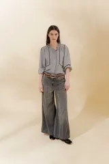 Pantalón jean gris de corte sastrero, tiro medio bajo y pierna ancha.