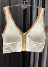 Top deportivo color piel con cierre frontal y ribete color beige.