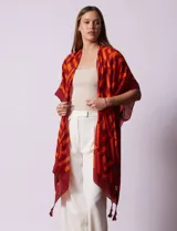 Kimono tejido con estampado geométrico en blanco y negro, ruedo con borlas y composición 100% poliéster.