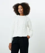 Suéter blanco de punto trenzado con cuello redondo y mangas largas.