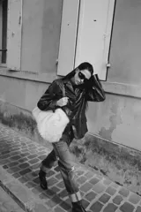 Blazer entallada de cuero negro con cuello solapa, manga larga con abertura, bolsillos con solapa y cierre frontal con botones.