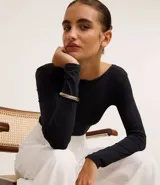 Pulsera rígida dorada con textura trenzada y cierre de muelle.