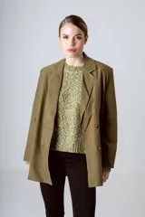 Blazer color beige con doble botonadura, solapas de muesca y corte holgado.