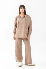 Conjunto de buzo con capucha y pantalón de punto color beige.