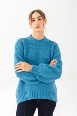 Buzo de punto color celeste, con cuello redondo y mangas largas de corte holgado.