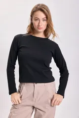 Remera negra de tejido rib con mangas largas y cuello redondo.
